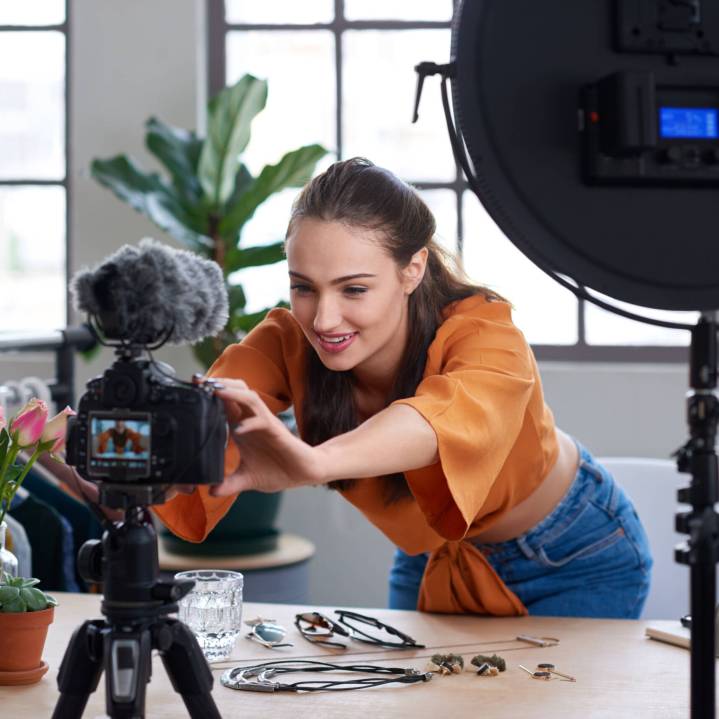 Young female vlogger adjusting her video equipment to record for her lifestyle fashion channel